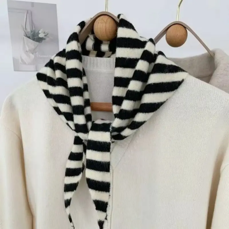 Schwarz-weiß gestreiftes gestricktes Dreieckstuch an einem Kleiderbügel