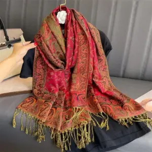 Rotes Tuch mit Paisley-Muster und Fransen, locker über einem schwarzen Oberteil drapiert