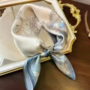 Quadratisches Halstuch in Grau und Blau mit Blumenmuster auf goldenem Tablett